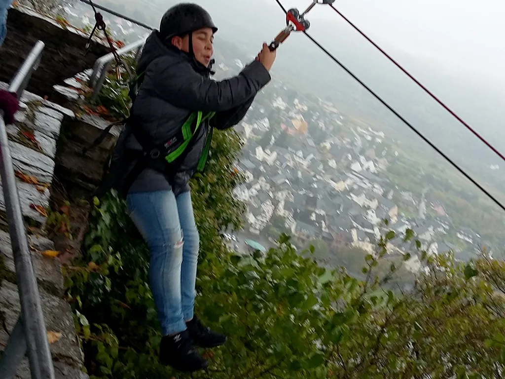 Person gleitet an der Seilrutsche über den Hang.